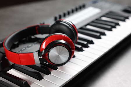 MIDI keyboard and headphones on gray table, closeupの写真素材
