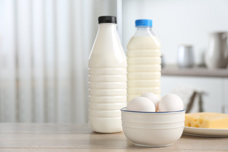 Different dairy products and eggs on wooden table in kitchen. Space for textの写真素材