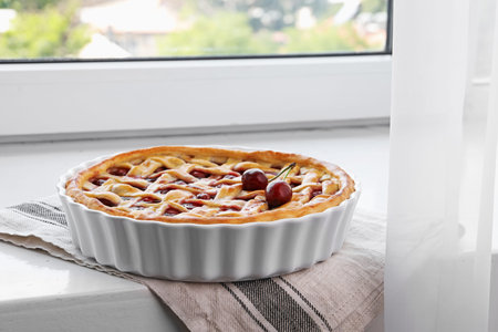 Tasty cherry pie on windowsill indoors, closeupの写真素材