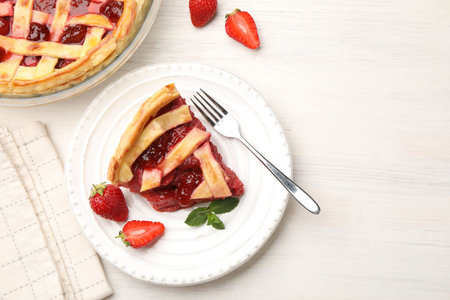Piece of tasty strawberry pie and berries on white wooden table, flat lay. Space for textの写真素材