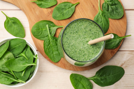 Tasty smoothie and spinach leaves on white wooden, flat layの写真素材