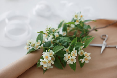 Jasmine branches, scissors and kraft paper on white table, closeupの写真素材