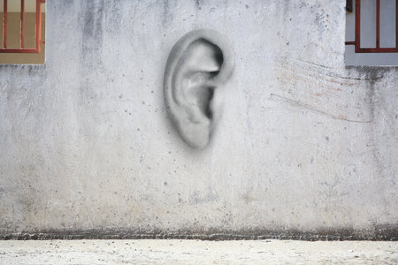 Human ear in old white wall. Eavesdropping, concept that even walls have earsの写真素材