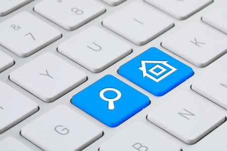 Online accommodation search. Buttons with house and magnifying glass icons on computer keyboard, closeupの写真素材