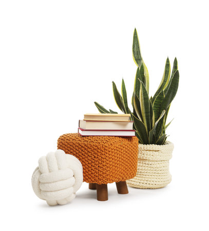 Stylish pouf with books and home decor isolated on whiteの写真素材