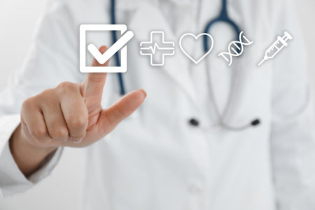 Doctor putting tick into checkbox on virtual screen with healthcare icons, closeupのeditorial素材
