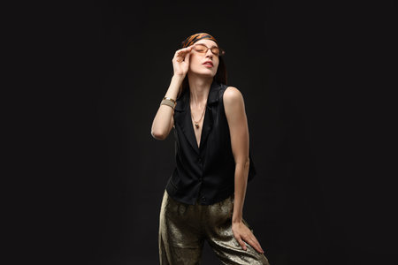 Portrait of beautiful woman in stylish outfit on black background