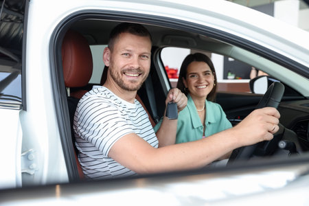 Happy family with keys inside new car