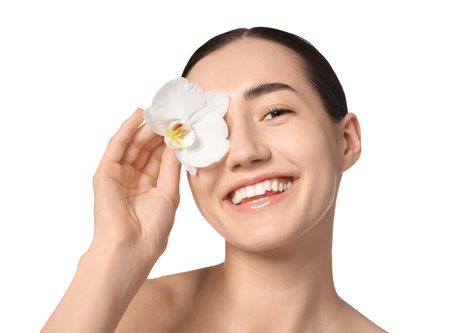 Portrait of smiling woman with orchid flower after spa treatment on white background, closeupの写真素材