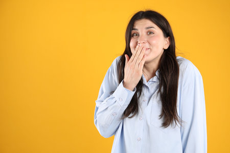 Portrait of surprised woman on orange background, space for textの写真素材