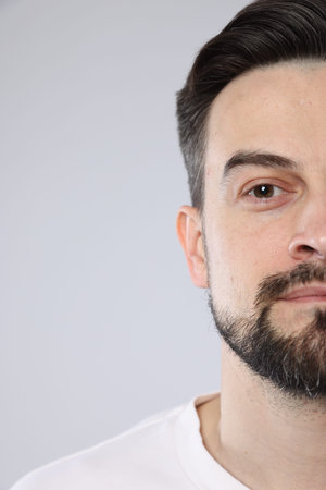 Handsome man on grey background, closeup view