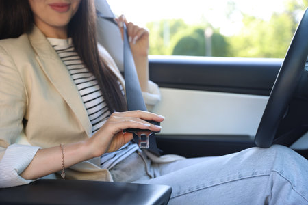 Woman fastening seat belt in modern car, closeupの写真素材