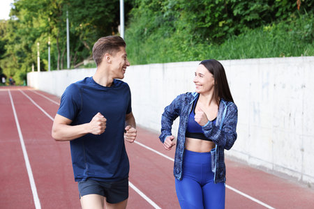 Sporty couple running at stadium. Healthy lifestyle