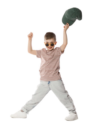 Happy little boy in sunglasses holding baseball hat and dancing on white backgroundの写真素材