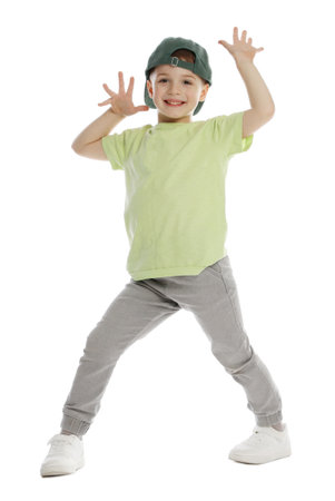 Happy little boy in baseball hat dancing on white backgroundの写真素材