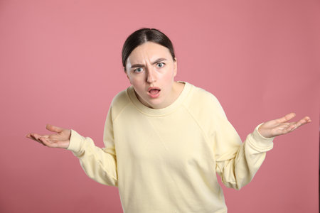 Portrait of shocked woman on pink backgroundの写真素材