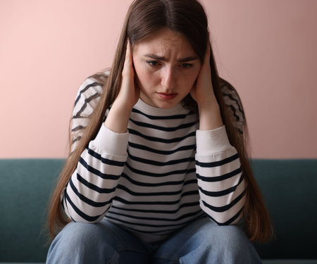 Woman suffering from paranoia on sofa at homeの写真素材