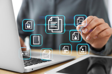 Woman working on laptop at table, closeup, Different document icons on virtual screenの写真素材