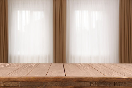 Empty wooden table against windows with curtains in roomの写真素材