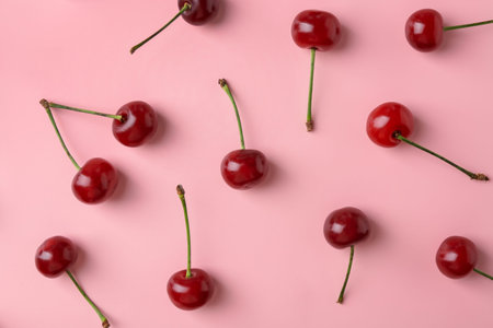 Fresh ripe cherries on pink background, flat lay