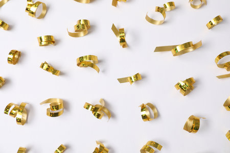 Shiny golden party streamers on white background, flat layの写真素材