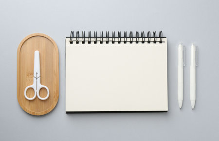 Notebook, scissors and pens on gray background, flat layの写真素材