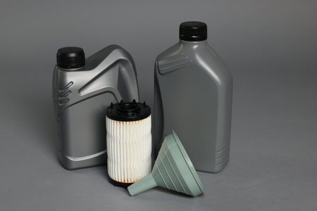 Motor oil in plastic canisters, filter and funnel on grey backgroundの写真素材