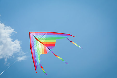 Colorful kite flying in blue sky, low angle view. Space for textの写真素材