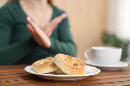 Gluten free diet. Woman refusing from pretzels indoors, selective focusの写真素材