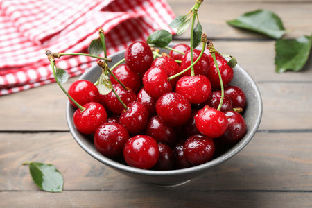 Fresh wet cherries in bowl on wooden table, closeupの写真素材
