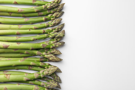 Fresh ripe raw asparagus on white background, flat lay. Space for textの写真素材