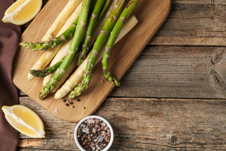 Different raw asparagus spears and spices on wooden table, flat lay. Space for textの写真素材