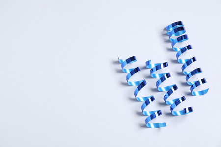 Shiny serpentine streamers on white background, above view. Space for textの写真素材