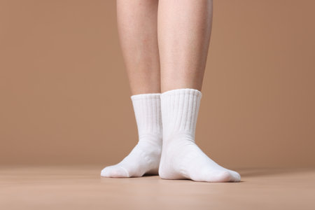 Woman in white socks on beige background, closeupの写真素材