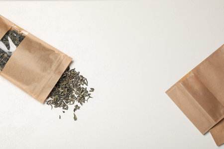 Zipper stand-up pouches and dry leaves on white table, flat lay. Mockup for designの写真素材