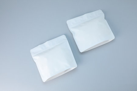Two zipper stand-up pouches on light gray background, flat lay. Mockup for designの写真素材