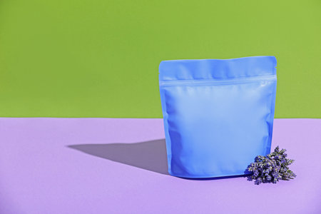 Zipper stand-up pouch and lavender flowers on color background, mockup for design