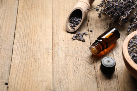 Natural essential oil and lavender flowers on wooden background, closeup. Space for textの写真素材