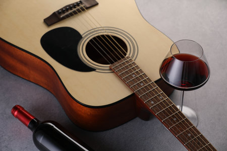 Acoustic guitar and red wine on gray table, closeupの写真素材