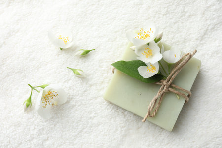 Soap bar and jasmine flowers on towel, flat layの写真素材