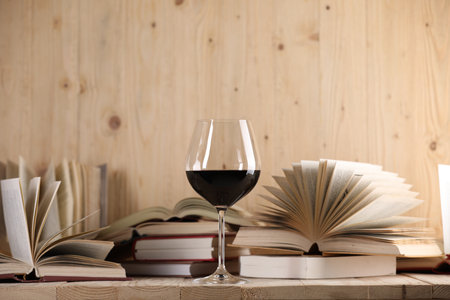 Glass of red wine and open books on wooden table. Space for textの写真素材