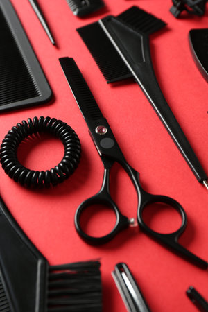 Different hairdresser's tools on red background, closeup