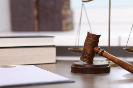 Judge. Gavel, scales, clipboard and books on wooden table in office, selective focus
