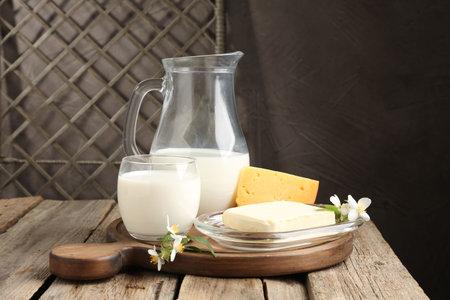 Different fresh dairy products and flowers on wooden tableの写真素材