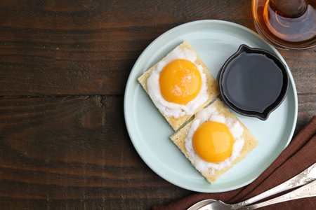 Traditional Asian breakfast with tasty kaya toasts and half-boiled eggs served on wooden table, flat...