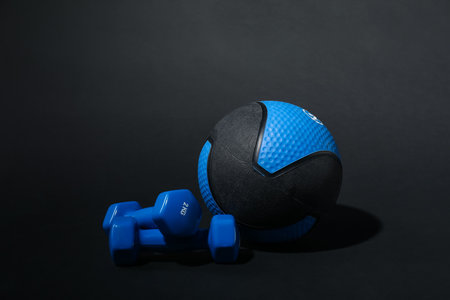 Medicine ball and dumbbells on black backgroundの写真素材
