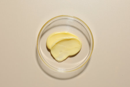 Cosmetic product in Petri dish on beige background, top viewの写真素材