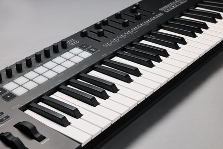 One portable MIDI keyboard on gray background, closeupの写真素材
