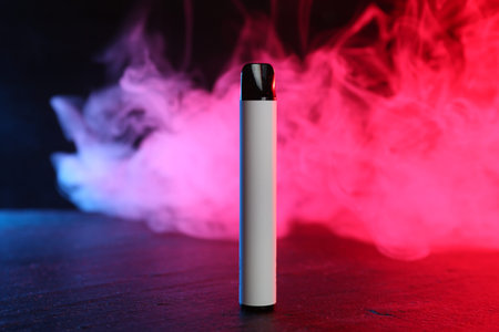 Electronic smoking device on black table in red light