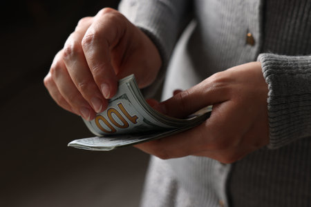 Woman counting her money indoors, closeup view